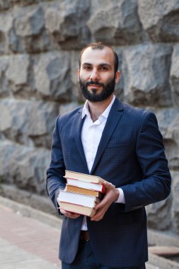 Pek çok kitap tutan genç adam