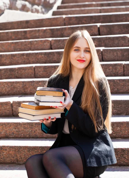 Krásné studentky sedí na schodech s Stoh knih — Stock fotografie