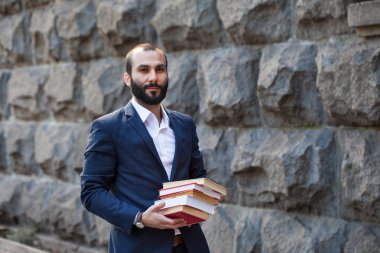 Pek çok kitap tutan genç adam