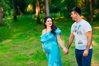 Güzel hamile çift dışında rahatlatıcı Park. 