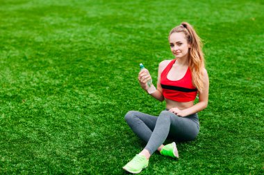 Güzel gülümseyen kadın sırasında parkta çim üzerinde rahatlatıcı