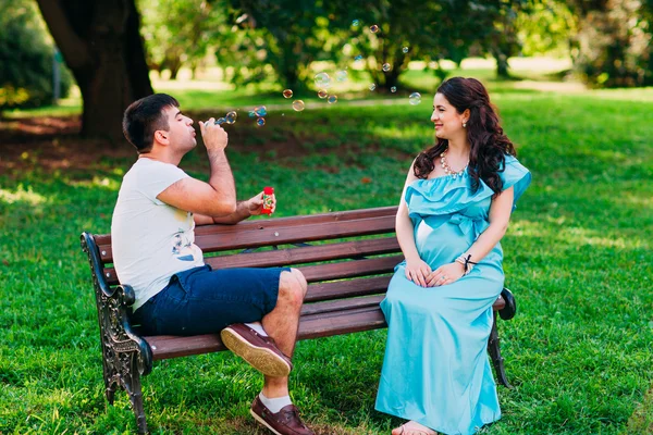 Bella coppia incinta rilassarsi all'aperto nel parco . — Foto Stock