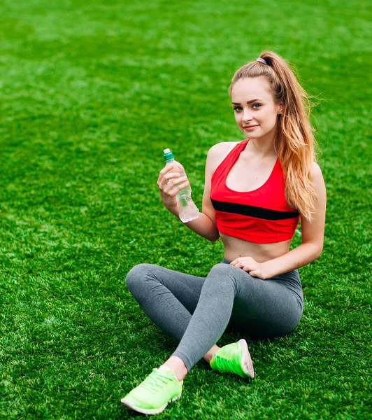 Belle femme souriante se détendre sur l'herbe dans le parc pendant — Photo