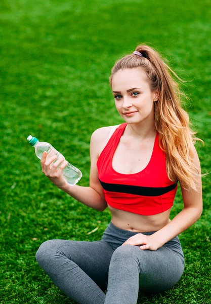 Belle femme souriante se détendre sur l'herbe dans le parc pendant — Photo