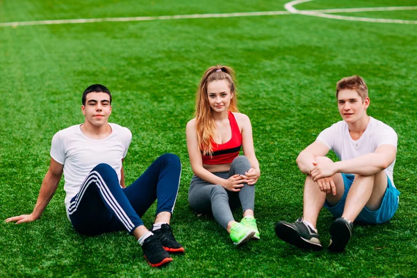 Young Sport ludzi siedzi na trawie — Zdjęcie stockowe