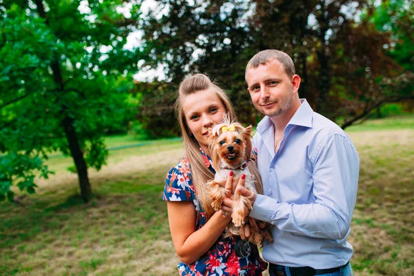 Happy young couple in love with dog. Park outdoors. — Stock Photo, Image