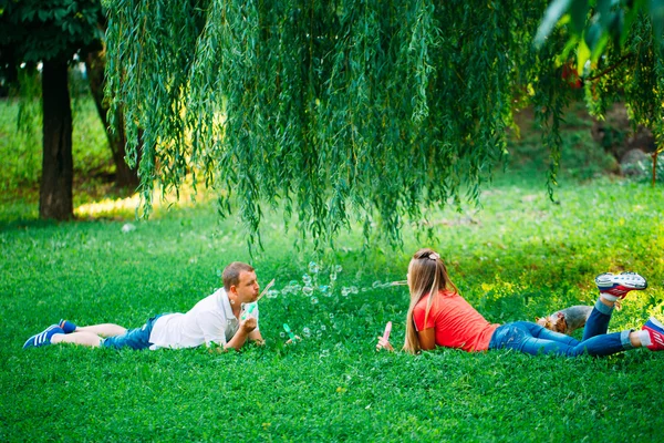 Casal Relaxante no Parque com soprador de bolhas. Hora da Primavera — Fotografia de Stock