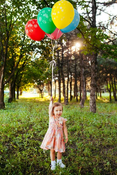 Bébé fille 2-3 ans tenant des ballons à l'extérieur. Fête d'anniversaire — Photo