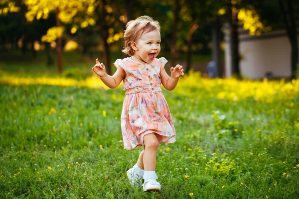 Happy cute little girl running on the grass in the park. Happine — Stock Photo, Image