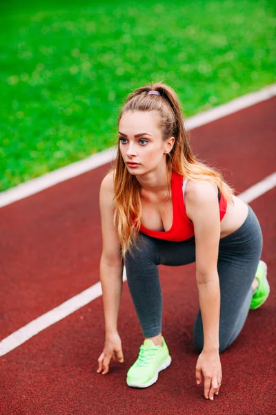 Kobieta lekkoatletycznego na torze zaczyna biegać. Pojęcie zdrowego fitness — Zdjęcie stockowe