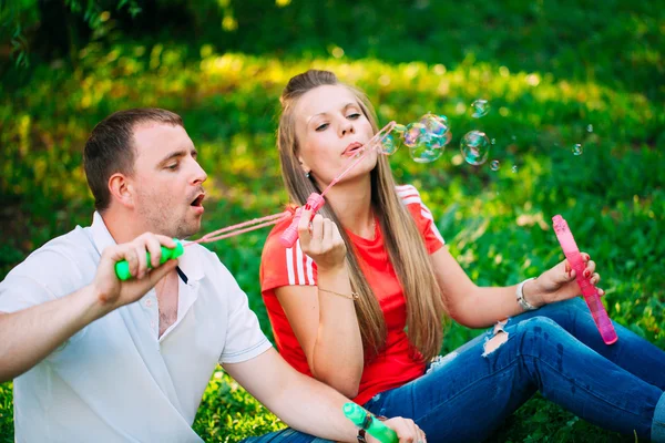 泡送風機が付いている公園のリラックスしたカップル。春の時間 — ストック写真