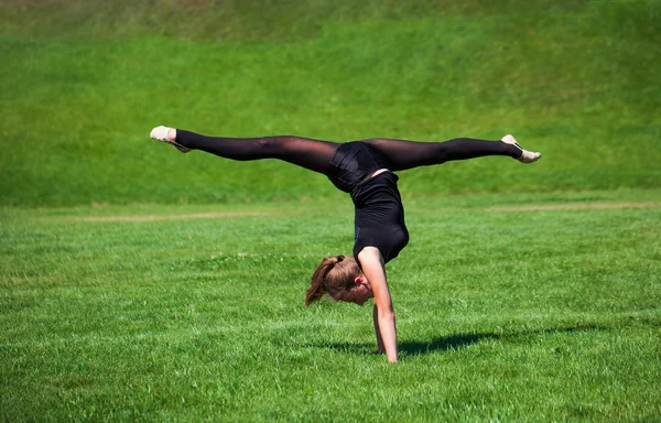 Young gymnast on grass in sunny day — Stock Photo, Image