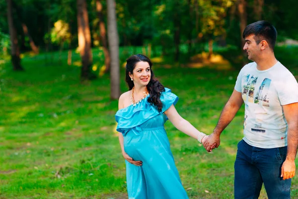 Beau couple enceinte se détendre à l'extérieur dans le parc . — Photo