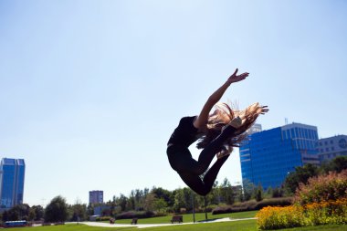 Gülümseyen genç jimnastikçi bölmedeki atlama ve yukarıda yüzen