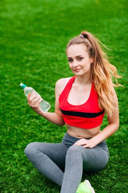 Güzel gülümseyen kadın sırasında parkta çim üzerinde rahatlatıcı