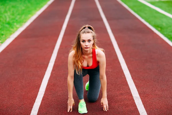 Kobieta lekkoatletycznego na torze zaczyna biegać. Pojęcie zdrowego fitness — Zdjęcie stockowe