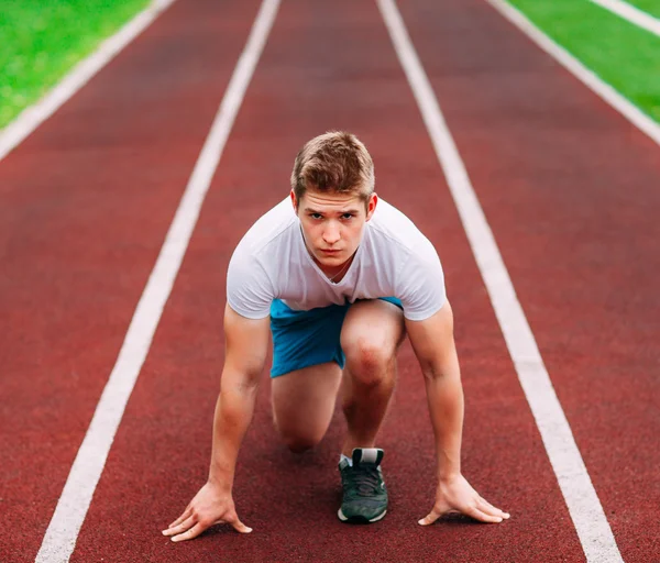 Mujer atlética en pista empezando a correr. Concepto de aptitud saludable — Foto de Stock