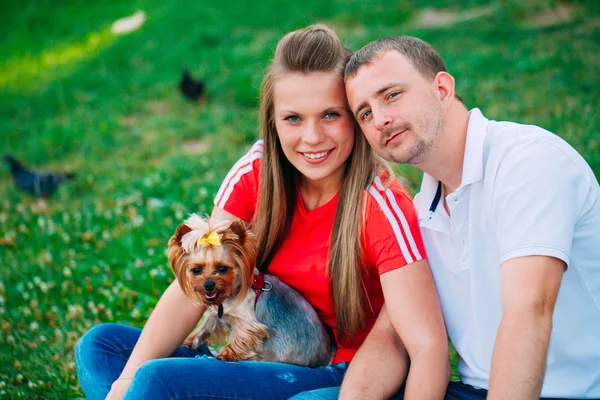 Feliz pareja joven enamorada de un perro. Parque al aire libre . —  Fotos de Stock
