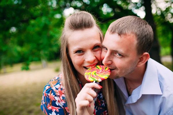 Du plaisir avec la sucette. Jeune couple aimant dégustation sucette multicolore — Photo