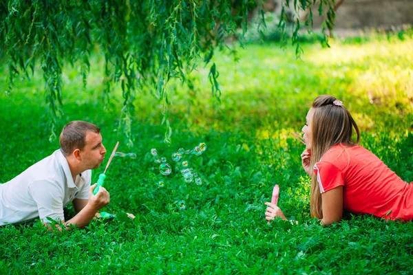 Casal Relaxante no Parque com soprador de bolhas. Hora da Primavera — Fotografia de Stock