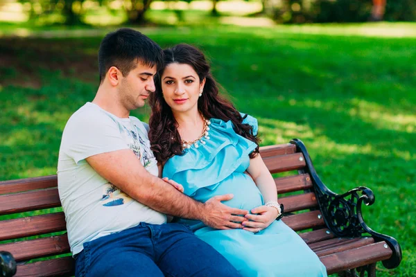 Beau couple enceinte se détendre à l'extérieur dans le parc . — Photo