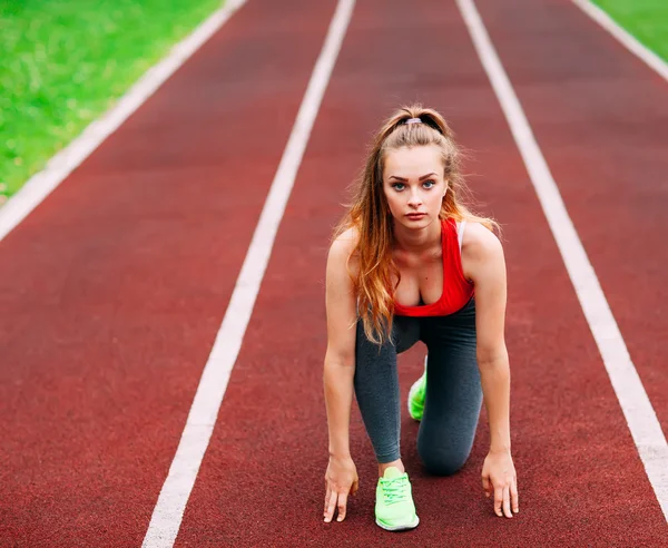 Kobieta lekkoatletycznego na torze zaczyna biegać. Pojęcie zdrowego fitness — Zdjęcie stockowe