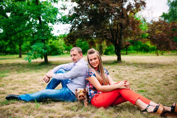 Feliz pareja joven enamorada de un perro. Parque al aire libre . —  Fotos de Stock