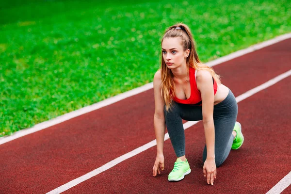 Mujer atlética en pista empezando a correr. Concepto de aptitud saludable — Foto de Stock