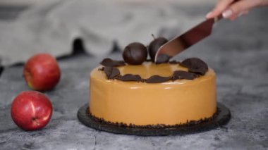 Karamelli elmalı mousse keki kesen kadın elleri. Sonbahar pastası. Fransız yemeği..