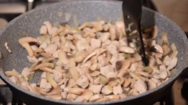 Kızarmış tavuk eti, mantar ve soğan kızartma tavasına yakın..