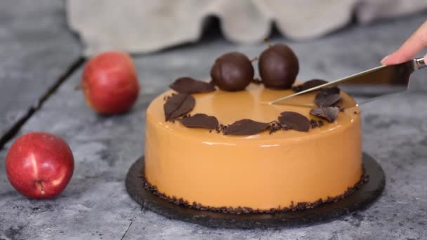 Vrouwelijke handen snijden een karamel appel mousse cake met spiegel glazuur. Herfst taart.Frans eten. — Stockvideo