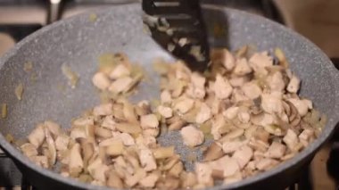 Kızarmış tavuk eti, mantar ve soğan kızartma tavasına yakın..