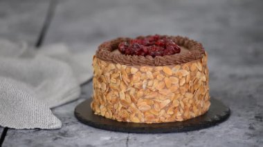 Çikolatalı pastayı kirazla süslemek. Pasta şefi ev yapımı kek pişiriyor..