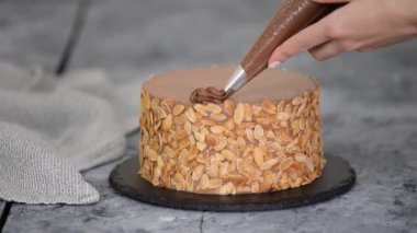 Şef çikolatalı keki kremayla süslüyor..