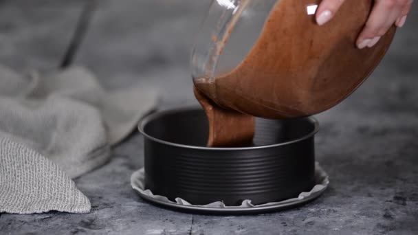 Mulher derramando massa de chocolate em uma panela. — Vídeo de Stock