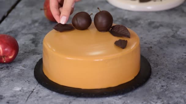 Pekařský kuchař zdobí dort čokoládovými jablky a listy. Pekařský šéfkuchař zdobený Moderní evropský dort. — Stock video