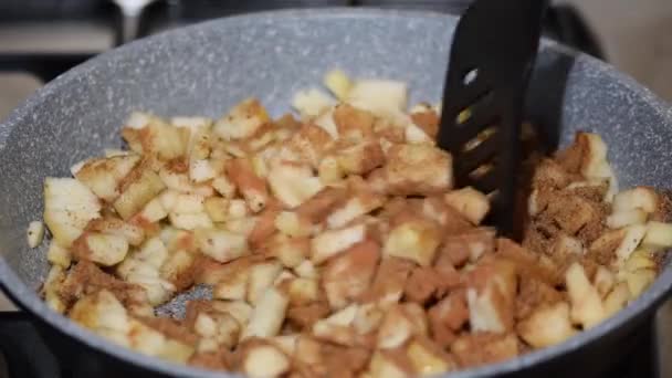 Προετοιμασία σπιτικού καραμελωμένου αχλαδιού σε τηγάνι με σκόνη κανέλας. Ανάδευση αχλαδιού στο τηγάνι. — Αρχείο Βίντεο
