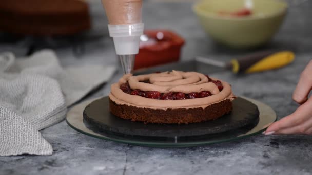 用巧克力奶油和饼干制作甜樱桃蛋糕的女性手的亲密接触. — 图库视频影像