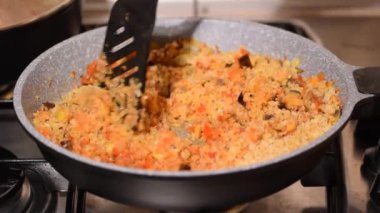 Bulgur 'u sebzelerle hazırlıyorum. Bulgur 'la sağlıklı öğle yemeği hazırlayan kadın..