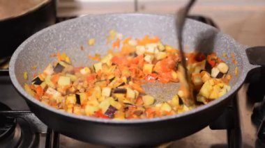 Kızartma tavasında sebze pişiren genç bir kadının yakın çekimi..