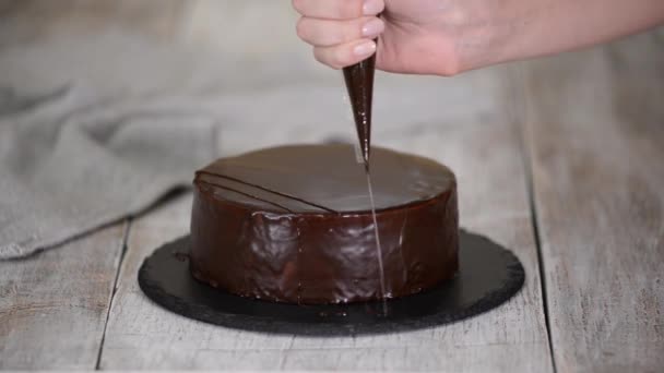 Chef-kok versieren de taart met gesmolten chocolade. — Stockvideo