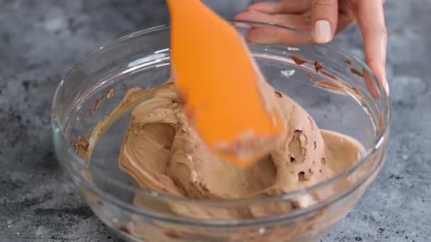 Mãos femininas mexendo creme de chocolate com uma espátula. — Vídeo de Stock