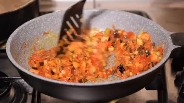 Primer plano de una joven cocinando verduras en una sartén. — Vídeos de Stock