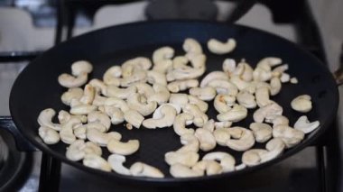 Yakın plan kaju fıstığı metal tavada kızarıyor..