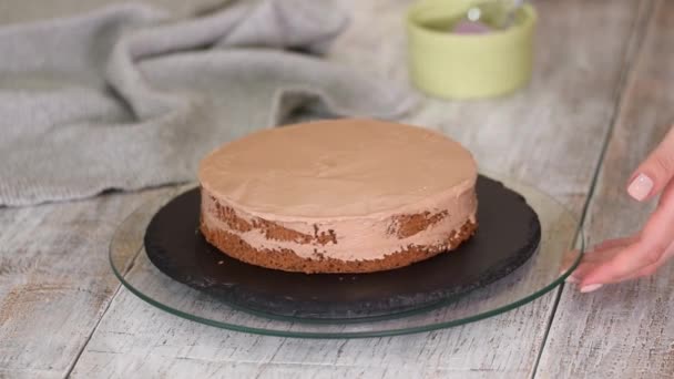 Vrouwen handen maken een zoete chocoladetaart met room — Stockvideo