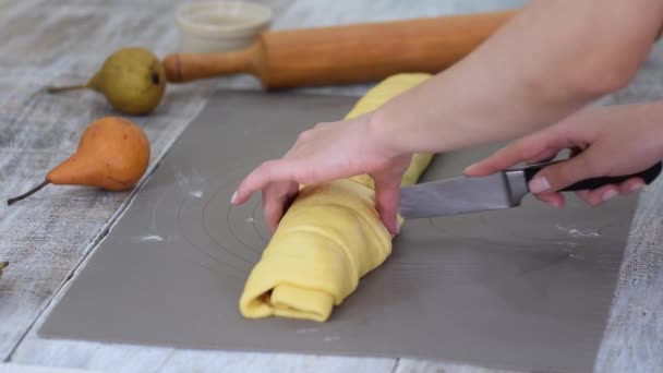 Γυναικεία χέρια που κόβουν σπιτική ζύμη από κανέλα αχλαδιού. Μια συνταγή βήμα προς βήμα για γλυκά ρολά κανέλας. — Αρχείο Βίντεο