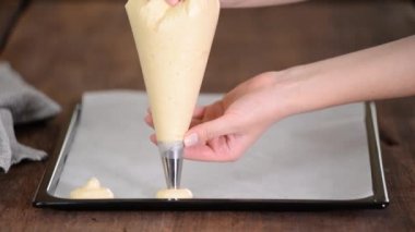 Kız bir hamur torbasının içindeki hamuru sıkıyor. Ev yapımı kurabiye yapıyorum.