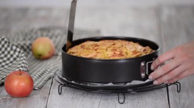 Mutfaktaki fırından yeni çıkmış elmalı keki çıkaran kadın..