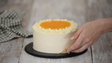 Kadın havuçlu keki doğranmış cevizle süslüyor..