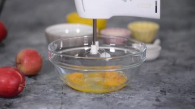 Şefin elleri çırpılmış yumurta ve şekeri cam bir kasede karıştırıcıyla çırpar..